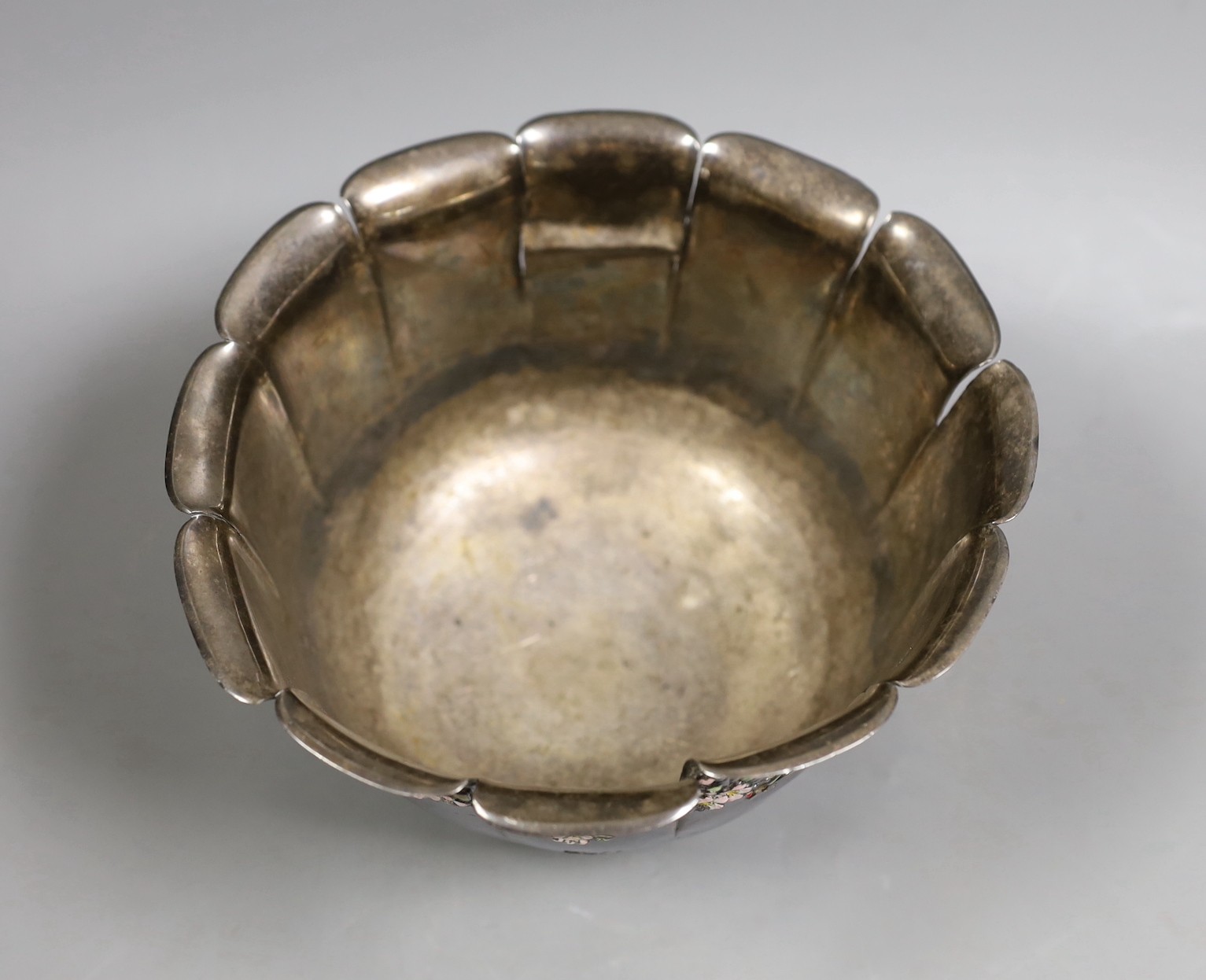 An early 20th century Japanese white metal fruit bowl with applied enamelled foliate decoration(a.f.) diameter 18.9cm, gross 14.2oz.